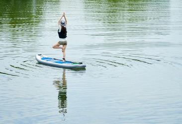 Kvinder laver yoga på SUP i vandet
