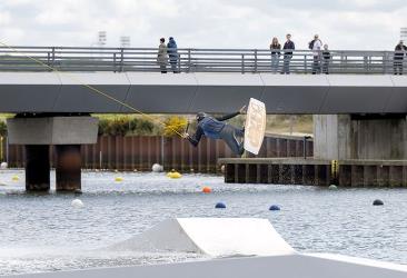 En mand laver tricks på wakeboardbanen